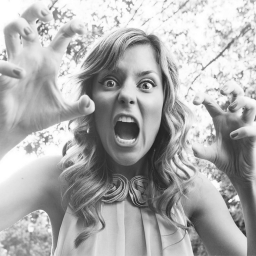 An image of Grace Helbig holding her hands up like claws.